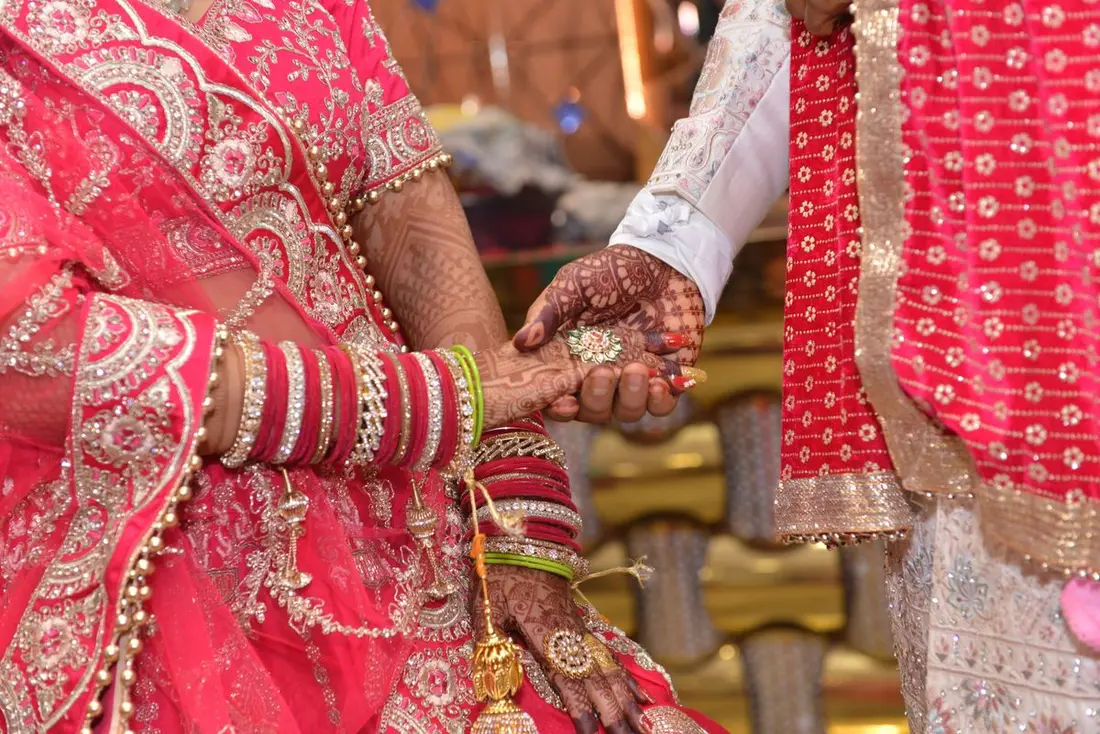 Couple in wedding finery beneath the evening sky